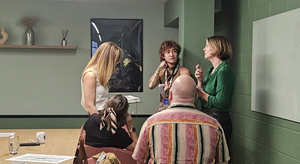 Image of a group of people standing in a circle talking