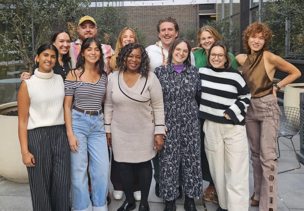 Image of ten people from diverse backgrounds standing in front of a camera smiling