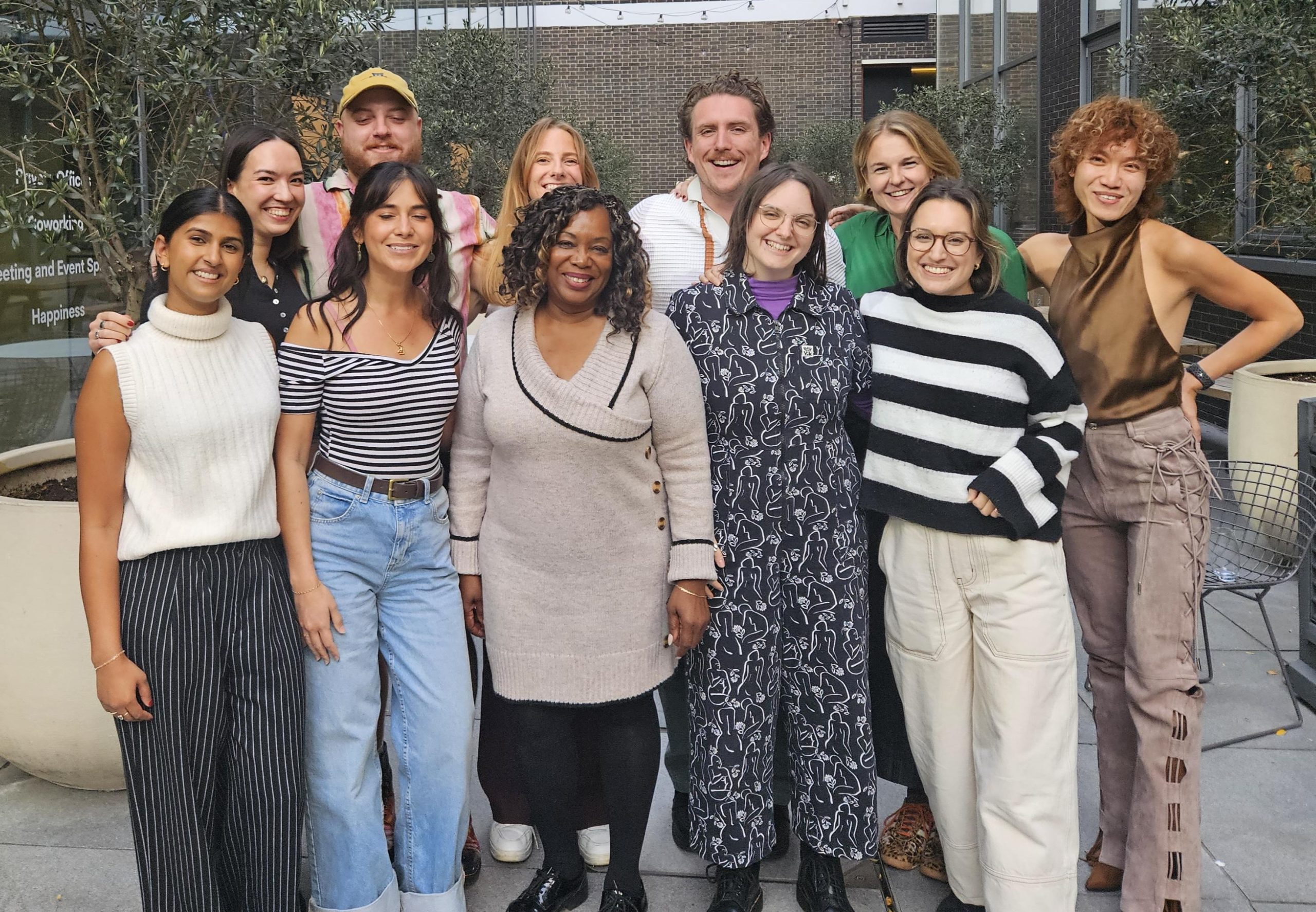Image of ten people from diverse backgrounds standing in front of a camera smiling